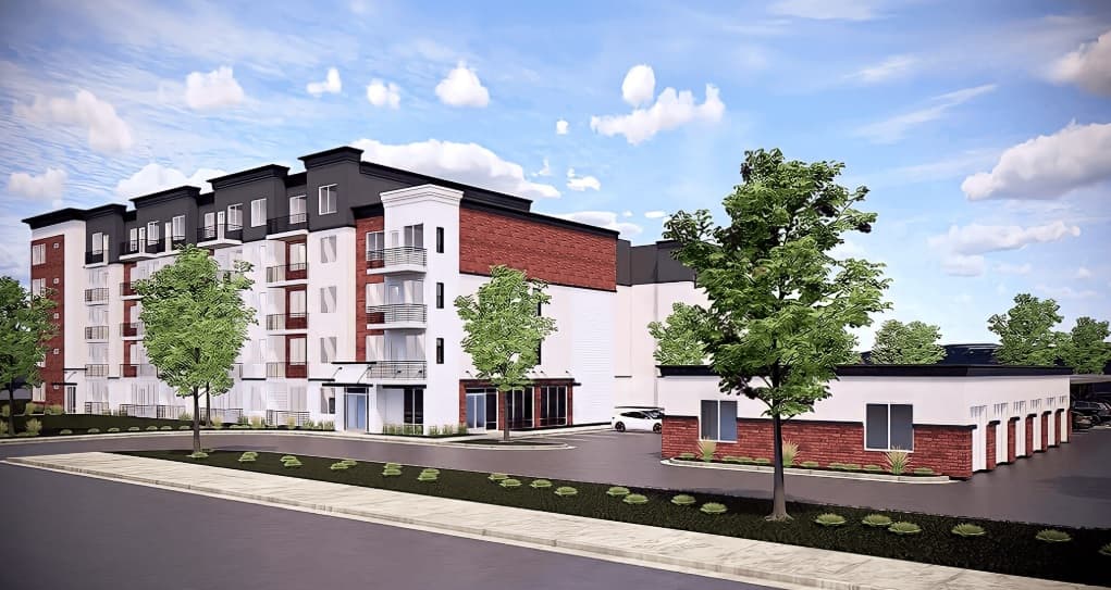 A modern multi-story apartment building at Hunter's Landing Ogden features a white and red brick exterior, balconies, large windows, and a nearby single-story structure, all surrounded by trees and landscaping under a partly cloudy sky.