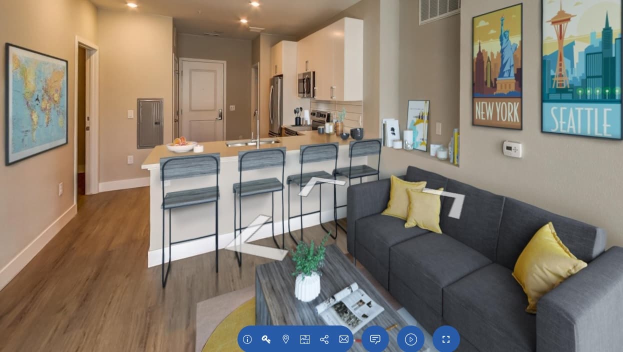 Modern apartment living room with gray sofa, yellow and white pillows, coffee table, and wall art of New York, Seattle, and a world map. Enjoy stylish comfort and stainless steel appliances when you live at CoLab Denver.