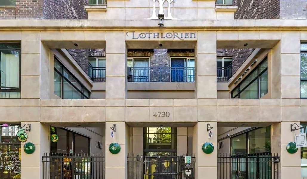 The entrance of Lothlorien at 4730 showcases large windows, balconies, and a gated black metal entryway—an inviting example of Seattle student housing managed by Yugo Seattle.