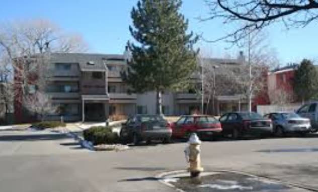 Fairways Apartments Boulder features a small complex of three-story buildings, several parked cars out front, leafless trees, and a fire hydrant in the parking lot on a clear day.
